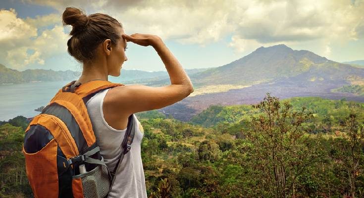 Woman traveler looking at Batur volcano. Indonesia.
