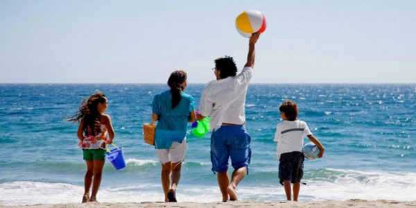 Image That Shows A Family Enjoying Their Vacation In The Beach.