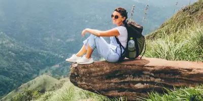 Woman Traveller Poses From A Mountain Peak In Her Travel.