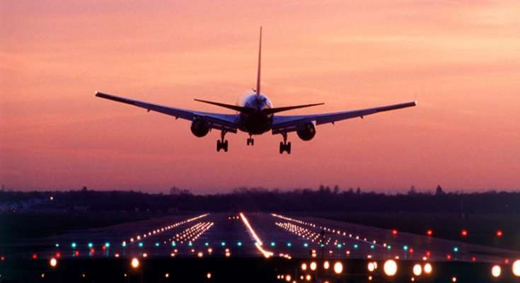 Image That Shows A White Airplane Flying In The Orange Sky Background.