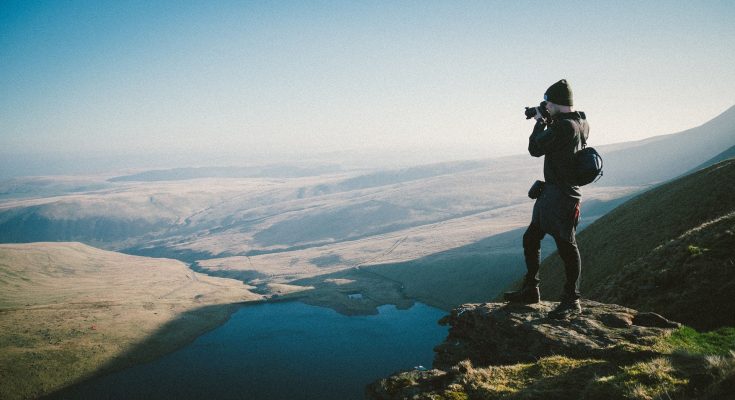 A Traveller Taking Snapshots From The Top of The Mountain